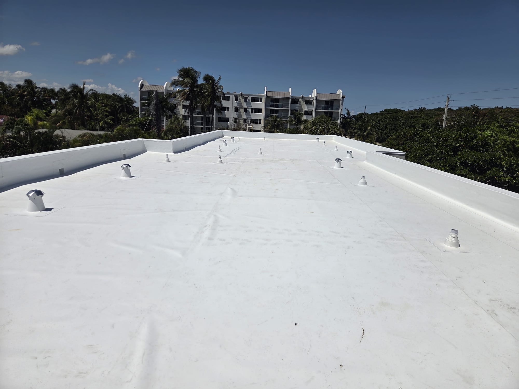 Finished white flat roof with new vent boots